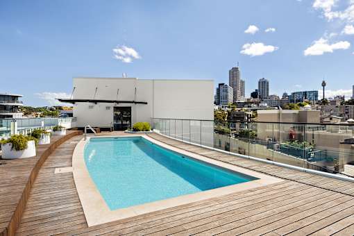 A modern building with a pool on the roof.