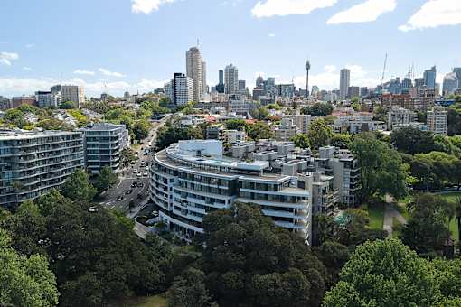 A cityscape with buildings and trees in the foreground.