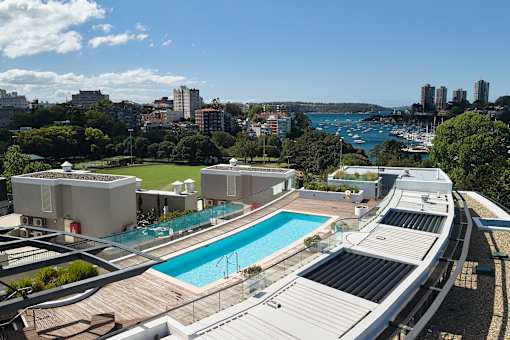 A view of a pool and apartment buildings from a high vantage point.