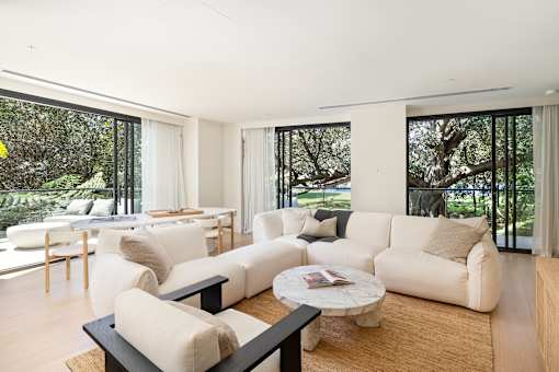 A living room with white furniture and a large window.