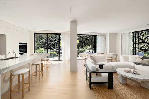 A modern living room with white furniture and a marble countertop.