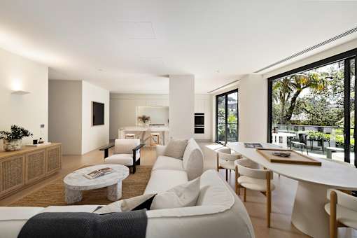 A modern living room with a white sofa and wooden furniture.
