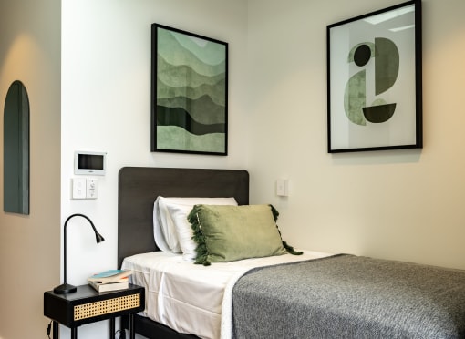 a bedroom with a bed and pictures on the wall