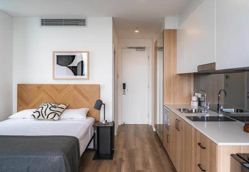 a hotel room with a bed and a kitchen