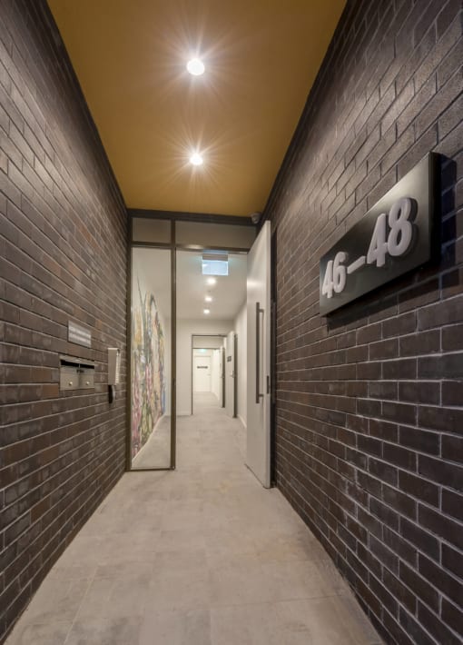 a long hallway with brick walls and glass doors