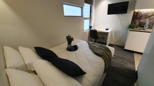 a bedroom with a bed and a couch with pillows