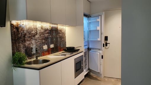 a small kitchen with a sink and a refrigerator