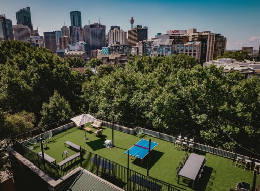 a yard with a tennis court and a city in the background