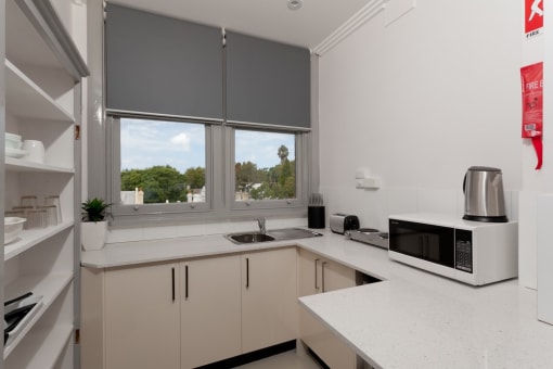 a kitchen with a sink and a microwave and a window