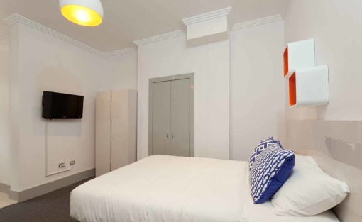 a bedroom with a bed and a television