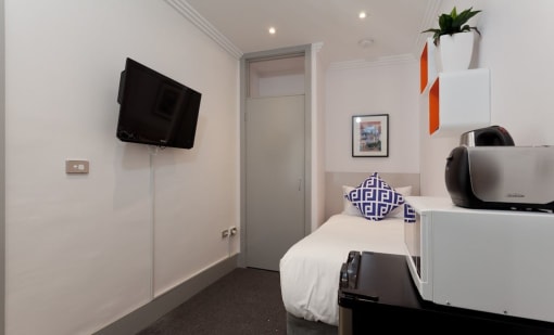 a small bedroom with a bed and a tv