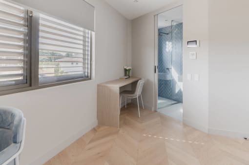 a room with a desk and a window and a shower
