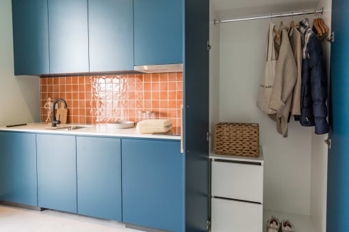 a kitchen with blue cabinets and a refrigerator and a closet