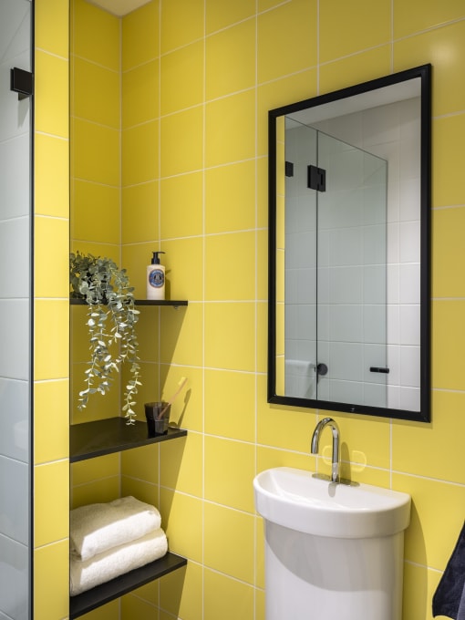 a yellow bathroom with a sink and a mirror