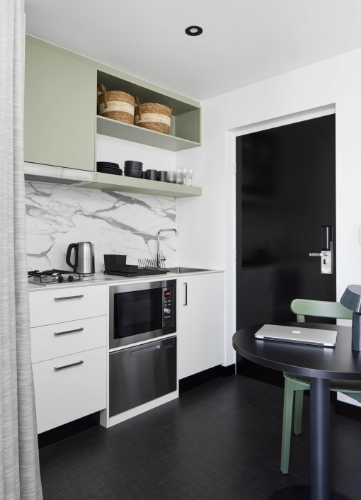 a small kitchen with a table and a black door