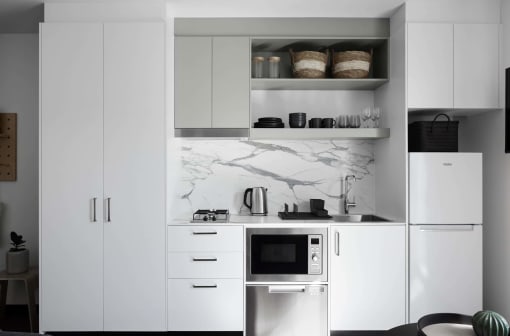 a black and white kitchen with white cabinets and a microwave