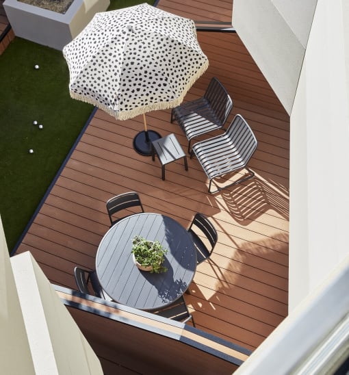 a deck with a table and chairs and an umbrella