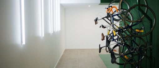 a bunch of bikes hanging on a wall in a room