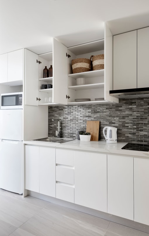 a white kitchen with white cabinets and a counter top