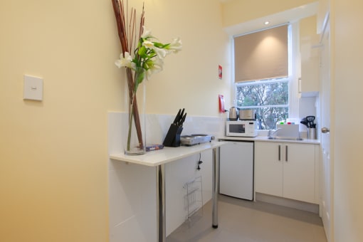 a kitchen with white cabinets and a sink and a window