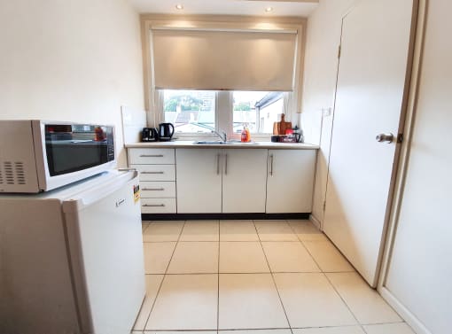 a kitchen with a sink and a microwave and a window