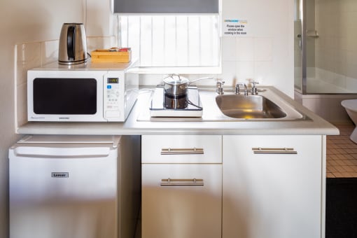 a kitchen with a microwave and sink and a sink and refrigerator