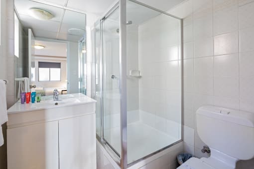 a bathroom with a shower and a sink and a toilet