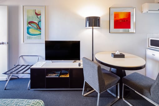 a living room with a tv and a table and chairs