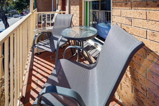 a patio with chairs and a table on a balcony