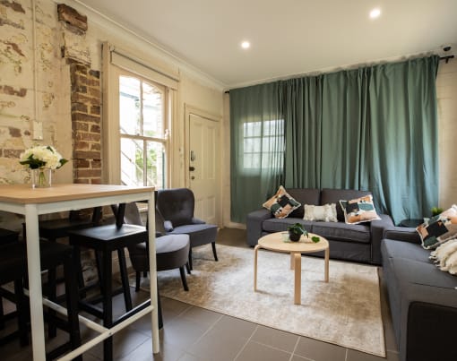 a living room with green curtains and a table and a couch