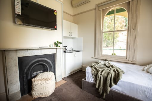 a bedroom with a fireplace and a bed and a television