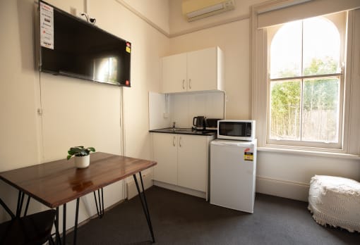 a small kitchen with a table and a refrigerator