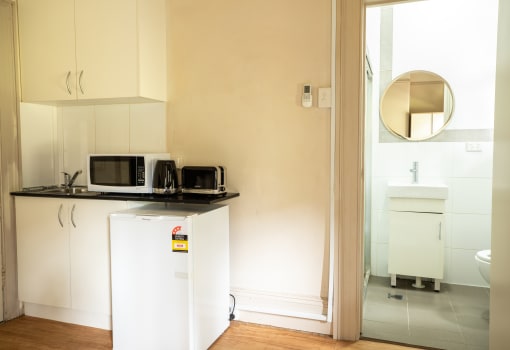 a small kitchen with a microwave and a refrigerator