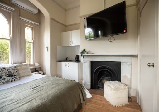 a bedroom with a fireplace and a tv above it