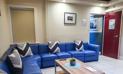 a living room with blue couches and a wooden table