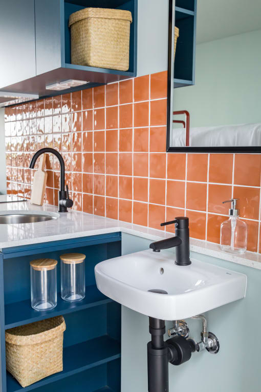 a white sink in a bathroom with orange tiles