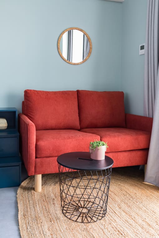 a living room with a red couch and a round table