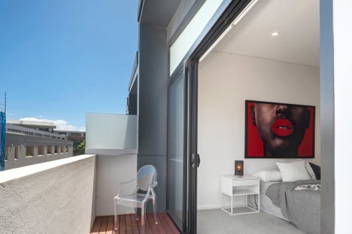 a small bedroom with a balcony and a door to a balcony