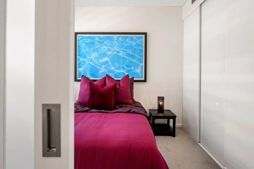 a bedroom with a bed and a picture of a pool