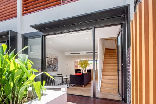 a living room with a staircase and a sliding glass door