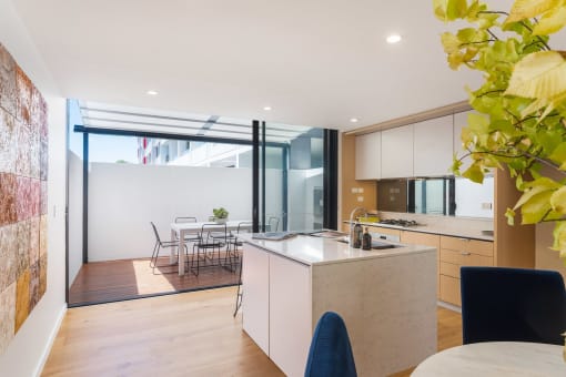 a kitchen with an island and a dining room with a table and chairs