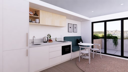 a white kitchen with a small table and a balcony