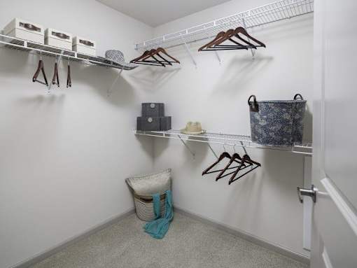 a closet with coats and shoes and a basket in it