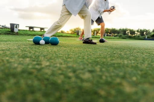 two people playing a game of golf on the grass