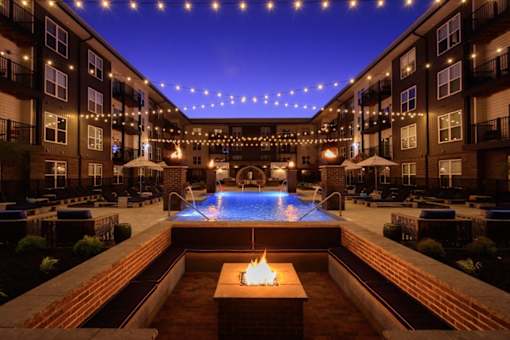 A pool with a fire pit in the middle of it.