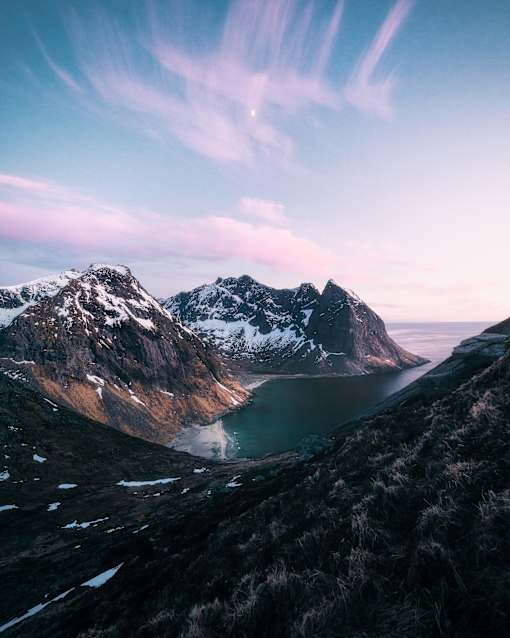 a view of a lake with snow covered mountains in the background