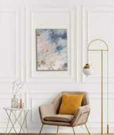 a living room with a chair and a painting on the wall