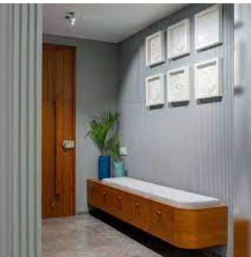 a room with a bench and pictures on the wall