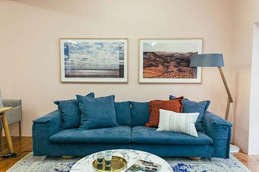 A blue couch with a tray on a coffee table in front of it.