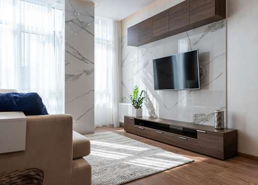 A modern living room with a flat screen TV mounted on the wall above a wooden console table.